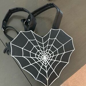 Black-and-white heart-shaped backpack. No tags, but never used. Brand new.